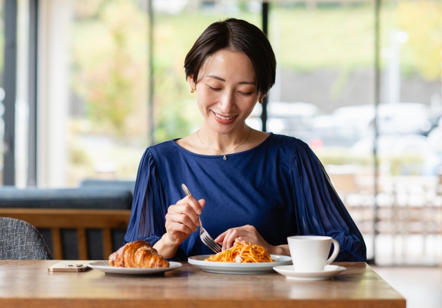 食事とコーヒーを楽しむ女性